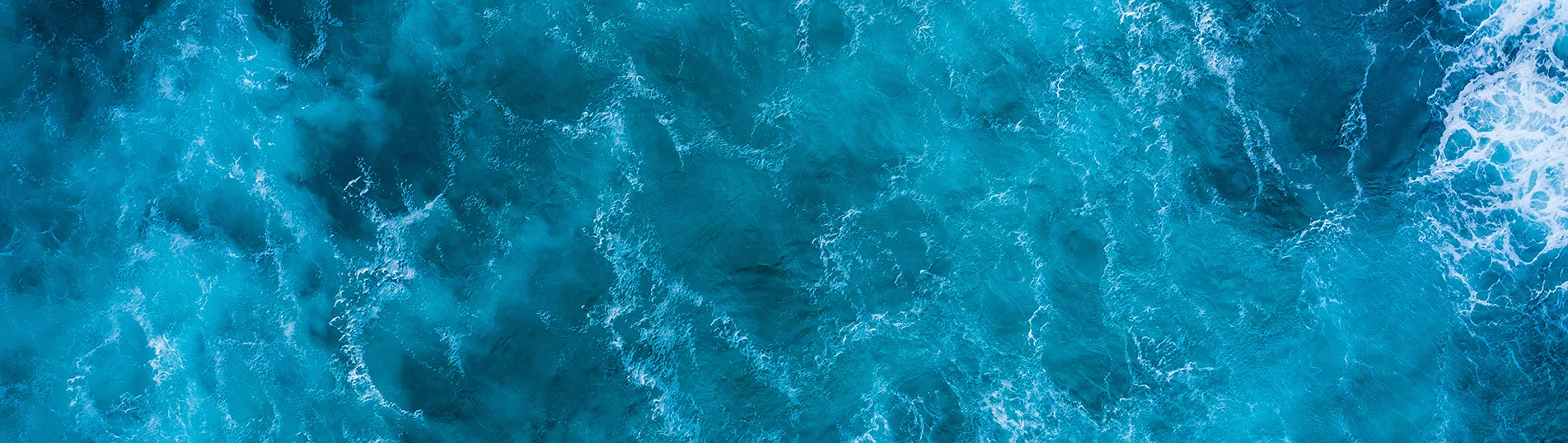 Top view of blue frothy sea surface. Shot in the open sea from a