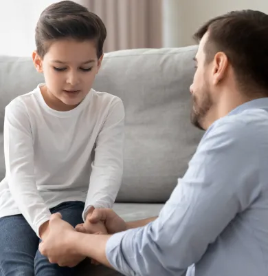 Father holding hands with his son, emphasizing parental support and understanding.