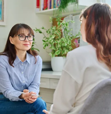 Therapist listening to a woman, illustrating open dialogue in therapy.